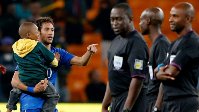 Neymar menggendong bocah usai Brasil mengalahkan Afrika Selatan