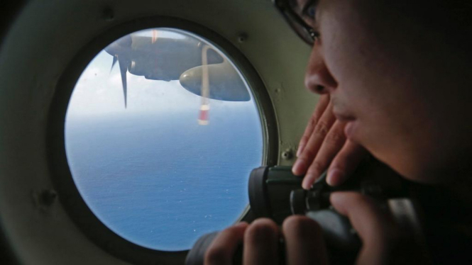 Seorang petugas mencari pesawat Malaysia Airlines yang hilang