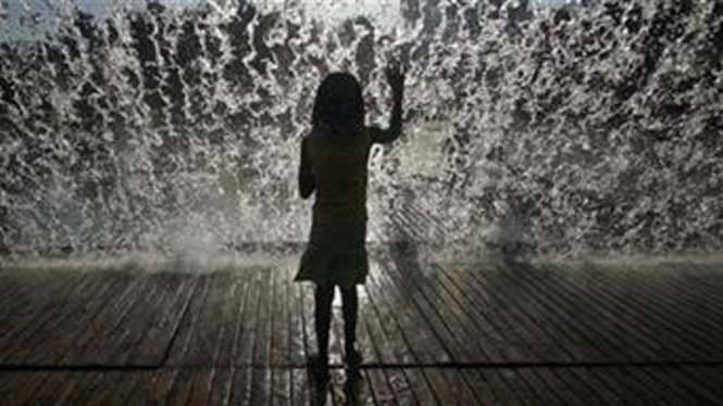 Seorang anak kecil menghadap air mancur