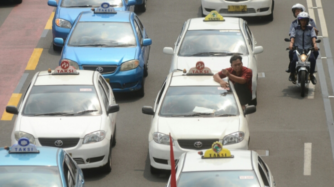 Sejumlah pengemudi taksi melakukan aksi unjuk rasa melintas di Jalan MH Thamrin, Jakarta, Rabu (30/4/2014).