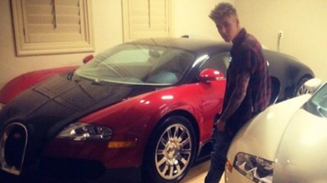 Justin Bieber berpose narsis di depan dua mobil Mayweather.