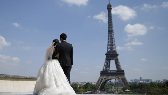 Sepasang pengantin baru dengan latar belakang Menara Eiffel Paris.