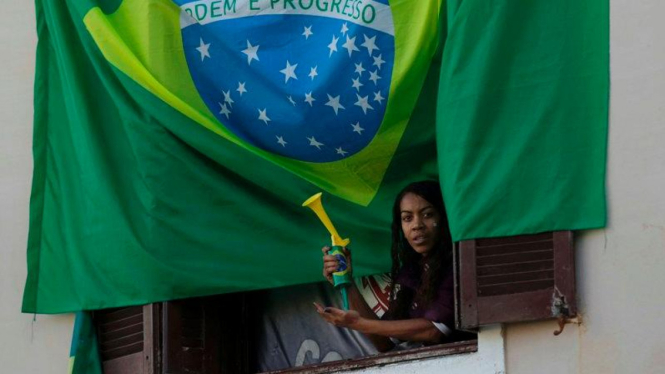 Warga Brasil memasang bendera Brasil jelang Piala Dunia