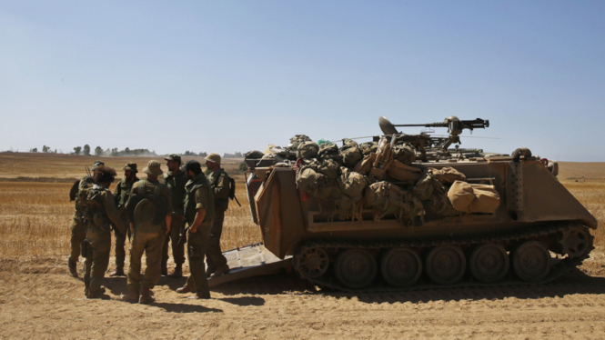 Tentara Israel berdiri dekat armoured personnel carrier (APC) 