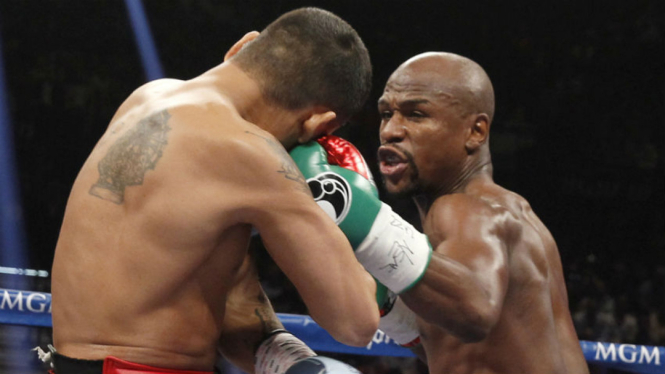 Floyd Mayweather Jr melayangkan pukulan (kanan)