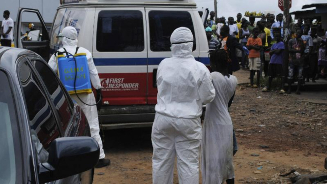 Pekerja kesehatan membawa seorang perempuan yang terjangkit Ebola ke ambulan