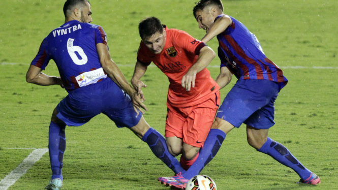 Pemain Bacerlona Lionel Messi dihadang dua pemain Levante