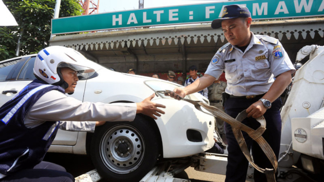 Petugas Dishub DKI Jakarta menderek sebuah mobil yang parkir liar di Jakarta Selatan beberapa waktu lalu. 