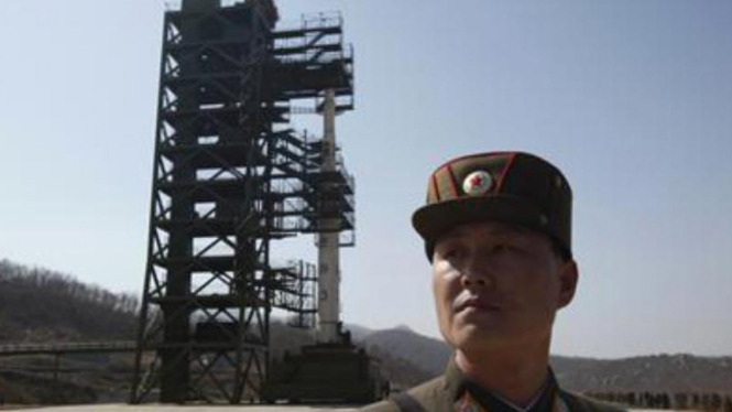 Tentara Korea berdiri di depan sebuah roket.