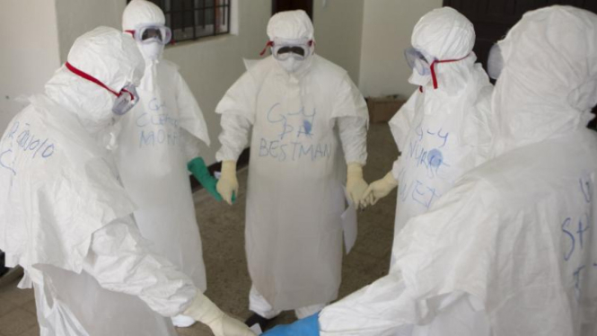 Pekerja kesehatan berdoa sebelum bertugas merawat pasien Ebola di Liberia.
