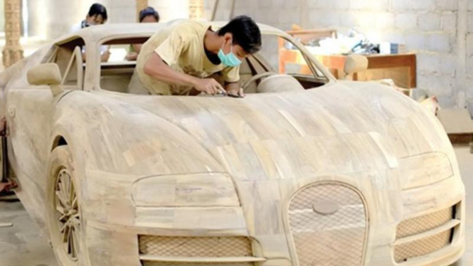 Para pekerja sedang merapikan replika Bugatti Veyron 