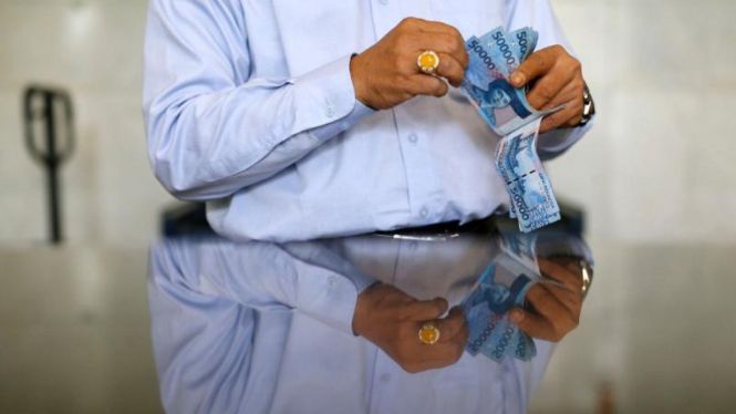 Seorang petugas bank saat menghitung uang di salah satu bank di Jakarta