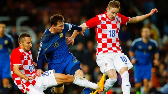 Lionel Messi diapit oleh dua pemain kroasia pada laga persahabatan