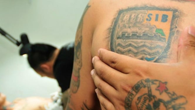 Seorang bobotoh usai dapatkan tato logo Persib gratis