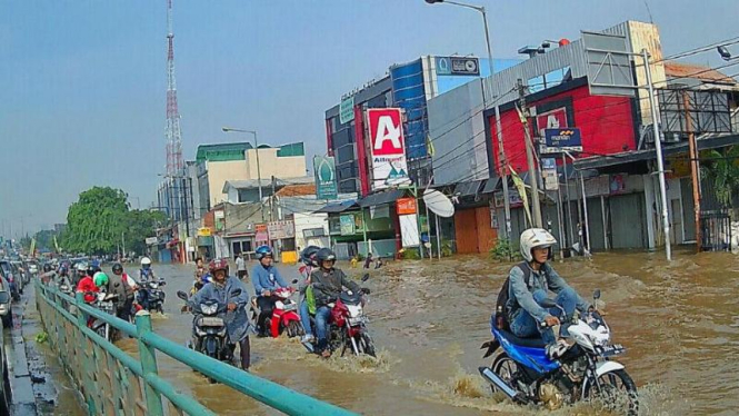 Banjir akibat luapan air Kali Ciliwung mulai naik ke jalan. Foto ilustrasi.