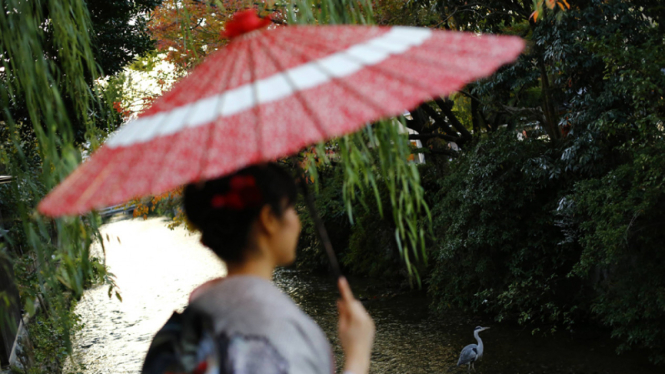 Seorang wanita Jepang pakai gaun tradisional kimono.