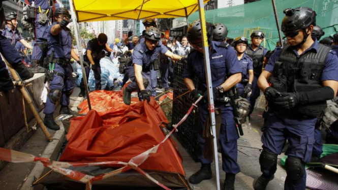 Polisi merubuhkan tenda pemrotes di distrik Mong Kong, Selasa 26 November.