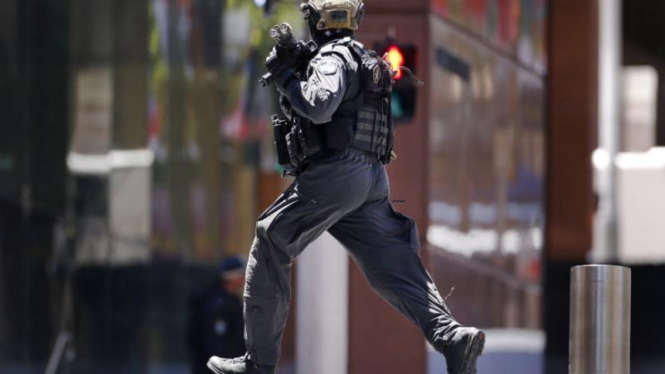 Seorang polisi berlari dekat lokasi penyanderaan di Sydney.