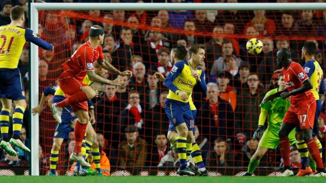Pemain Liverpool, Martin Skrtel, saat mencetak gol ke gawang Arsenal.