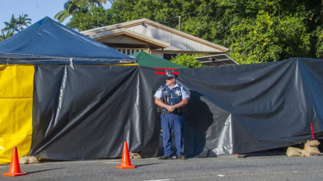 Seorang polisi menjaga lokasi tragedi pembunuhan delapan anak di Cairns.