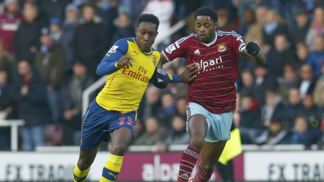 Danny Welbeck (kiri) berebut bola dengan Alex Song