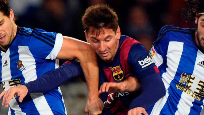 Pemain Barcelona, Lionel Messi, coba lewati dua pemain Real Sociedad