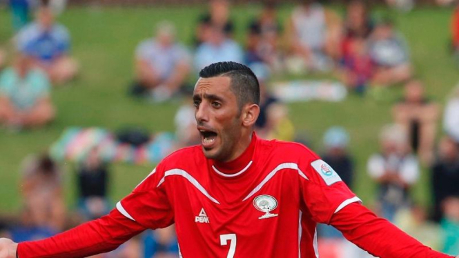 Pemain Palestina dengan latar penonton duduk di rumput Hunter Stadium