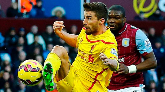 Pemain Liverpool, Fabio Borini, sedang mencetak gol.