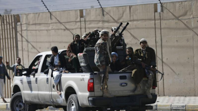 Militan Houthi dalam kendaraan militer di luar Istana Kepresidenan