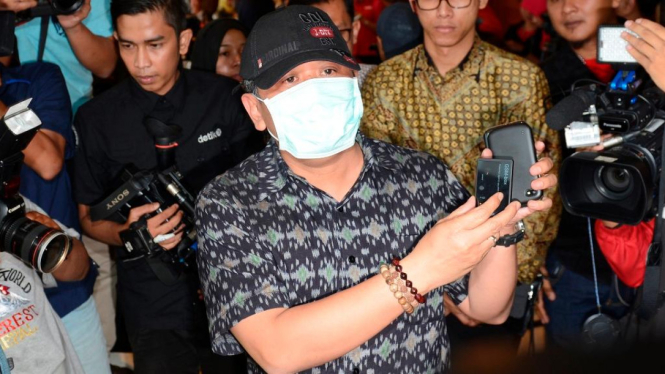 Plt Sekjen PDIP Hasto Kristiyanto memakai masker dan topi
