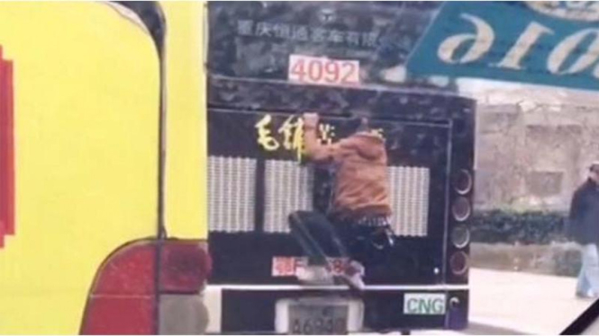 Aksi pria menggelantung di bagian belakang bus