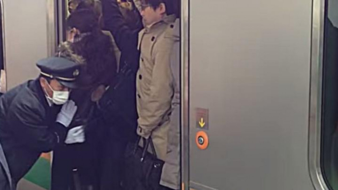 Oshiya bertugas mendorong orang masuk ke dalam kereta