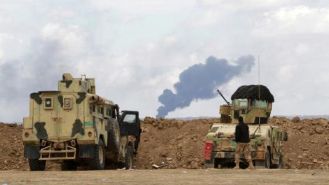 Tentara Irak melihat ke arah ladang minyak Ajil di Tikrit