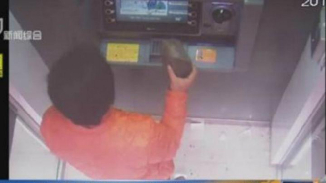 Seorang pemuda terekam kamera sedang merusak ATM