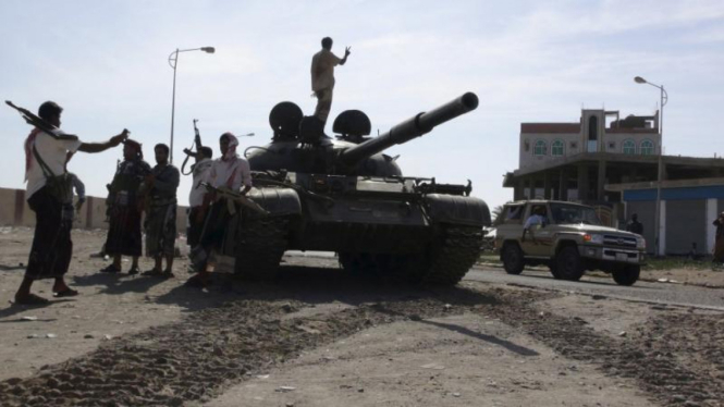 Milisi pendukung Presiden Yaman berfoto dekat tank di Aden.