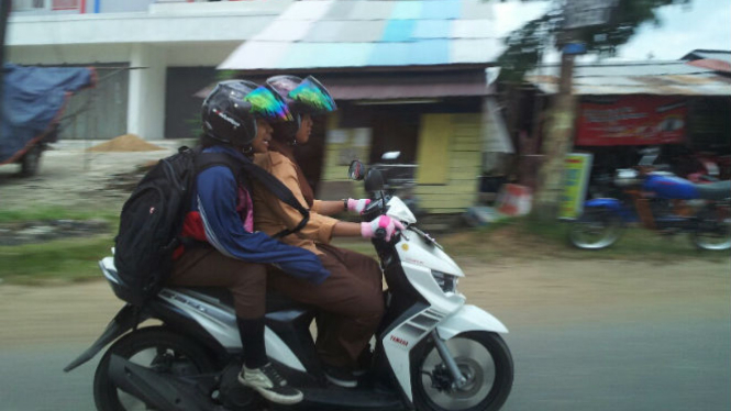 Pelajar mengendarai motor di Pontianak.