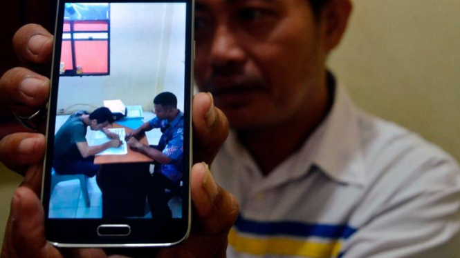 Seorang polisi tunjukkan foto seorang tahanan ikut Ujian Nasional