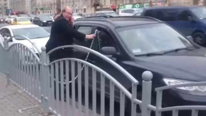 Pria mengamankan mobilnya dengan menggunakan rantai.