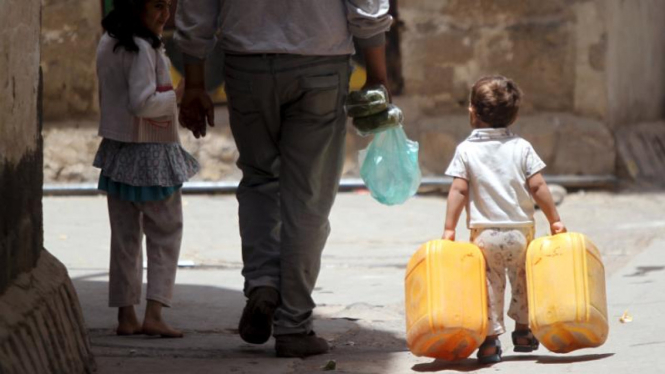 Seorang anak membawa jerigen di Sanaa yang kekurangan air bersih.
