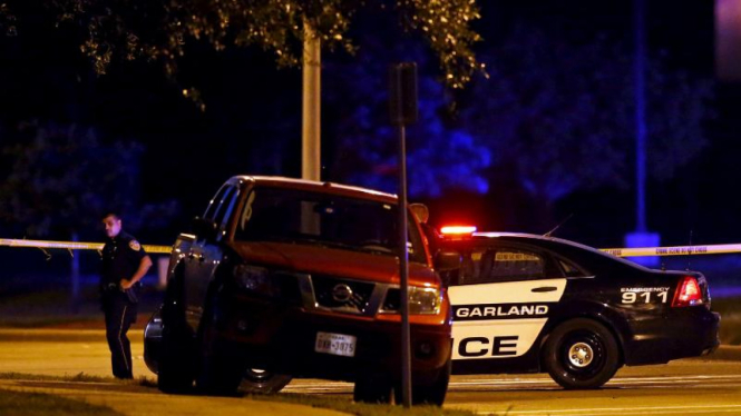 Polisi berdiri dekat mobil tersangka penembakan di Dallas, Texas, Amerika Serikat.