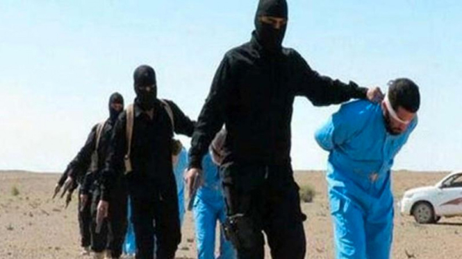 Kelompok militan ISIS dengan tahanan berbaju biru. Foto ilustrasi.