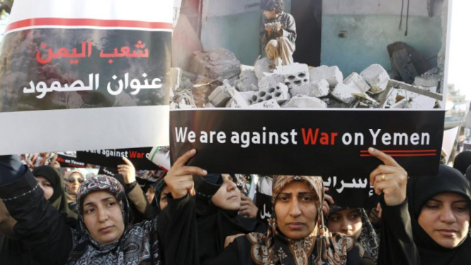 Para wanita membawa spanduk menentang serangan Saudi ke Yaman.