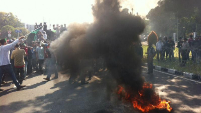 Mahasiswa membakar ban saat unjuk rasa di depan Istana Negara