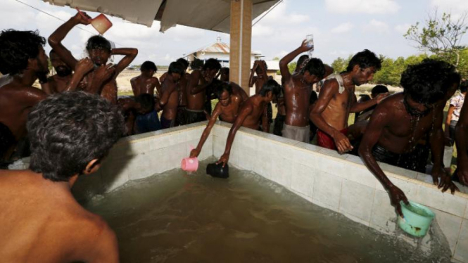 Migran Rohingya mandi di penampungan sementara, di Kuta Binje, Aceh.