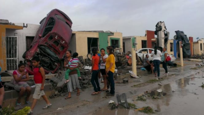 Warga berdiri di luar rumahnya yang rusak akibat tornado di Texas.