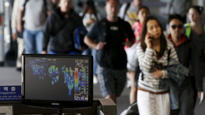 Penumpang pesawat melalui alat pemeriksaan suhu tubuh di Bandara Incheon.