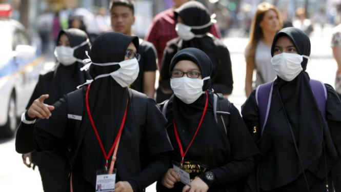 Turis mengenakan masker untuk menghindari MERS di Seoul.