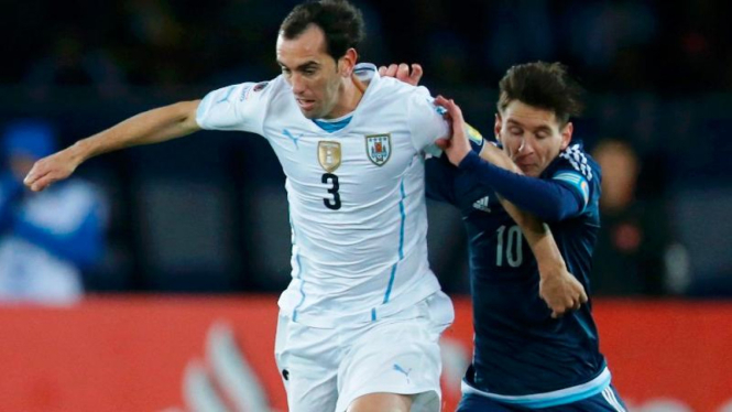 Bek Uruguay, Diego Godin berduel dengan penyerang Argentina, Lionel Messi