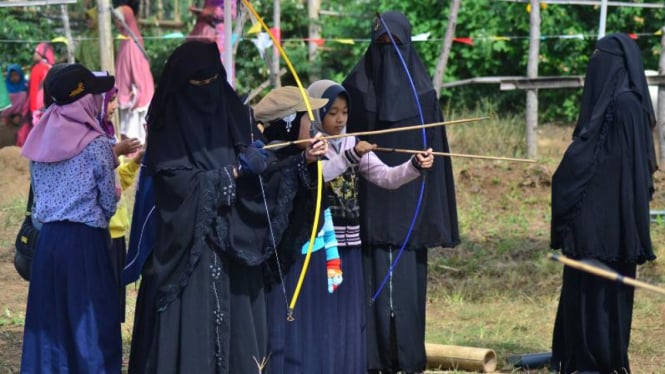 Santri wanita mengajarkan cara memanah kepada siswa SD