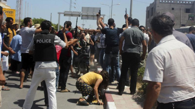 Polisi berusaha menenangkan kerumunan setelah serangan di Tunisia.